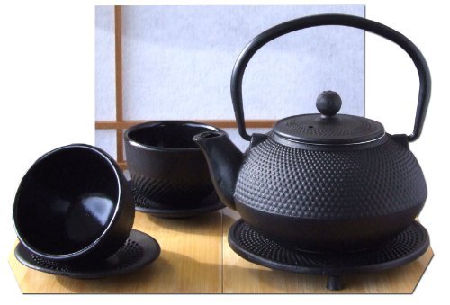 Théière en fonte avec tasses et dessous de théi...